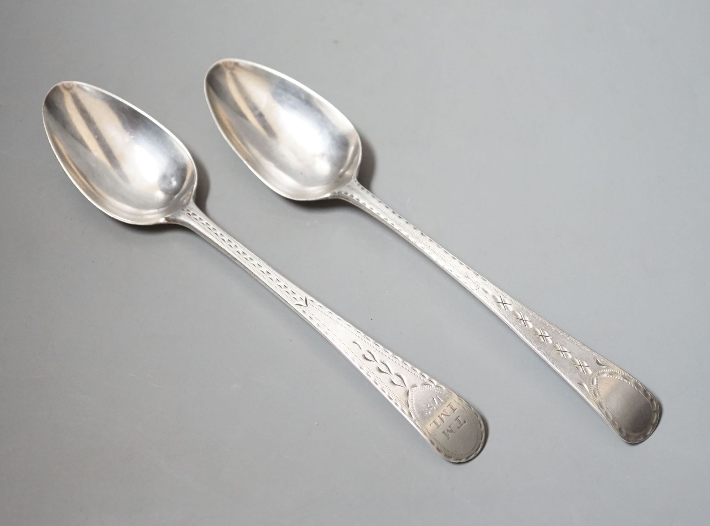A near pair of George III provincial silver Old English pattern table spoons, by Richard Ferris, Exeter, 1791, with differing bright engraving and one with engraved date and initials, 21.4cm, 110 grams
